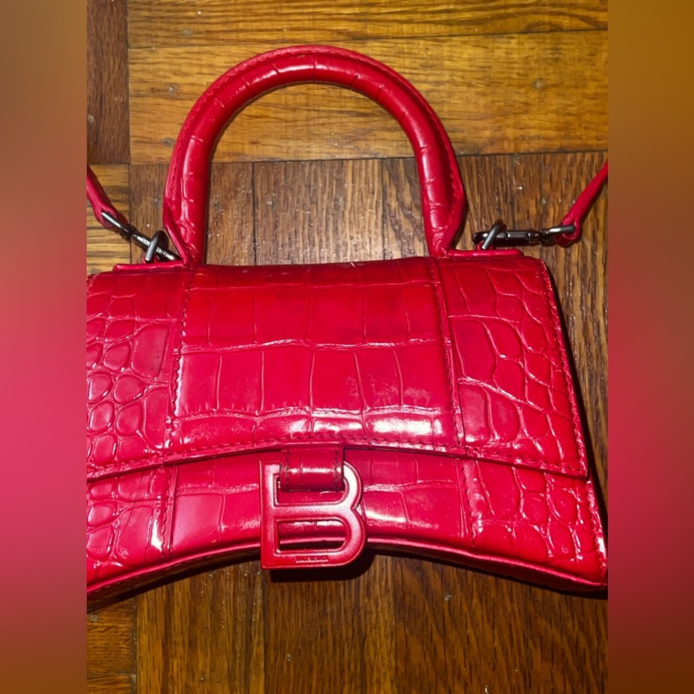 Red hourglass with silver balenciaga bag .